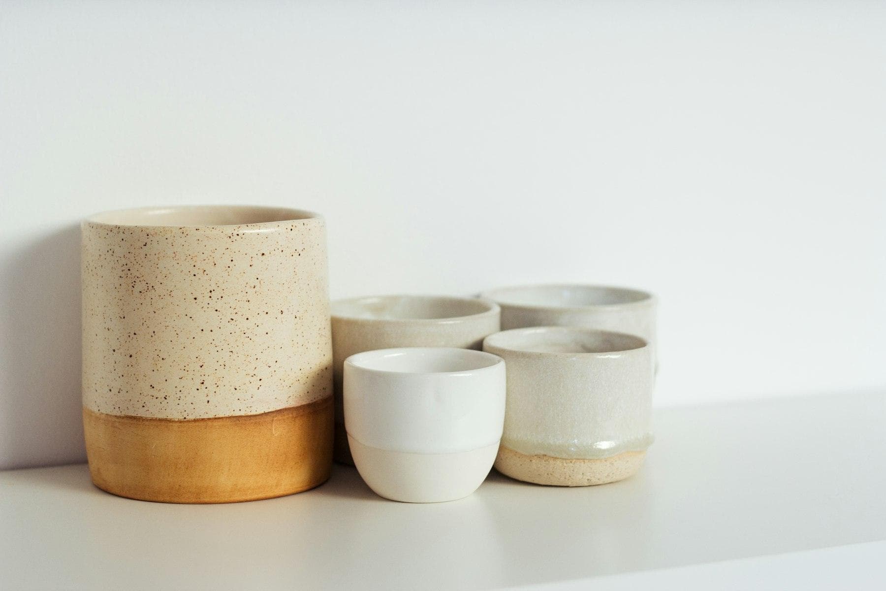 Set of handmade ceramic cups on a shelf