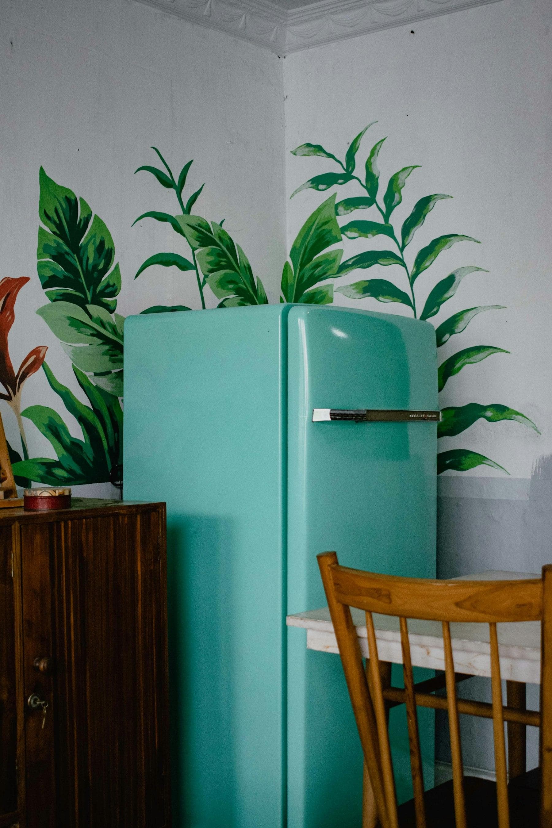 Retro teal refrigerator next to a wooden chair