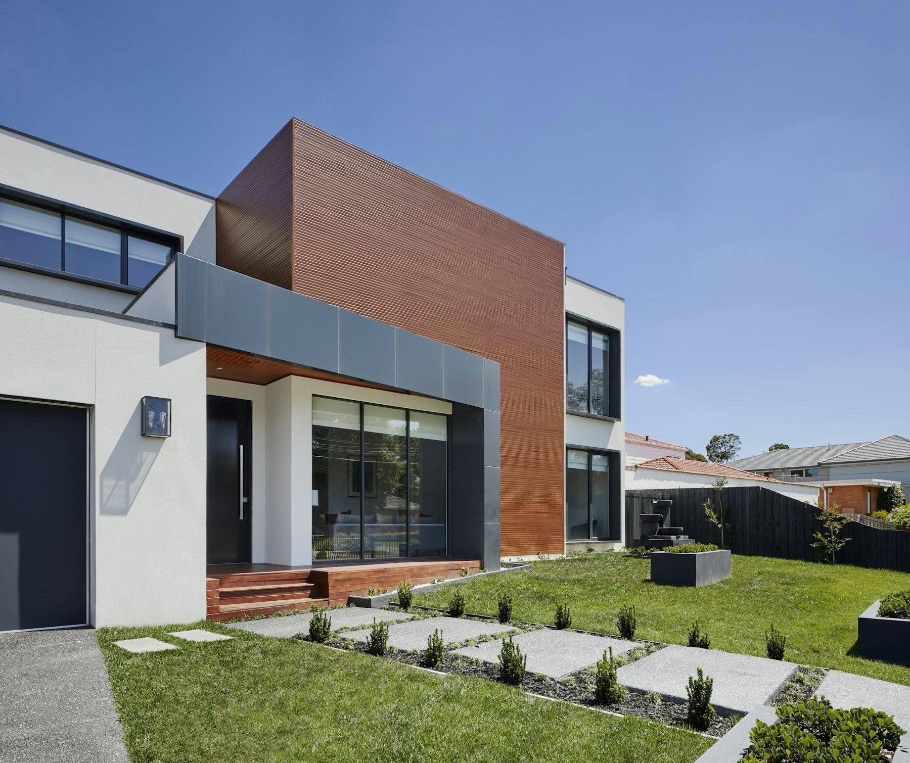 Contemporary townhouse with a timber facade and front lawn