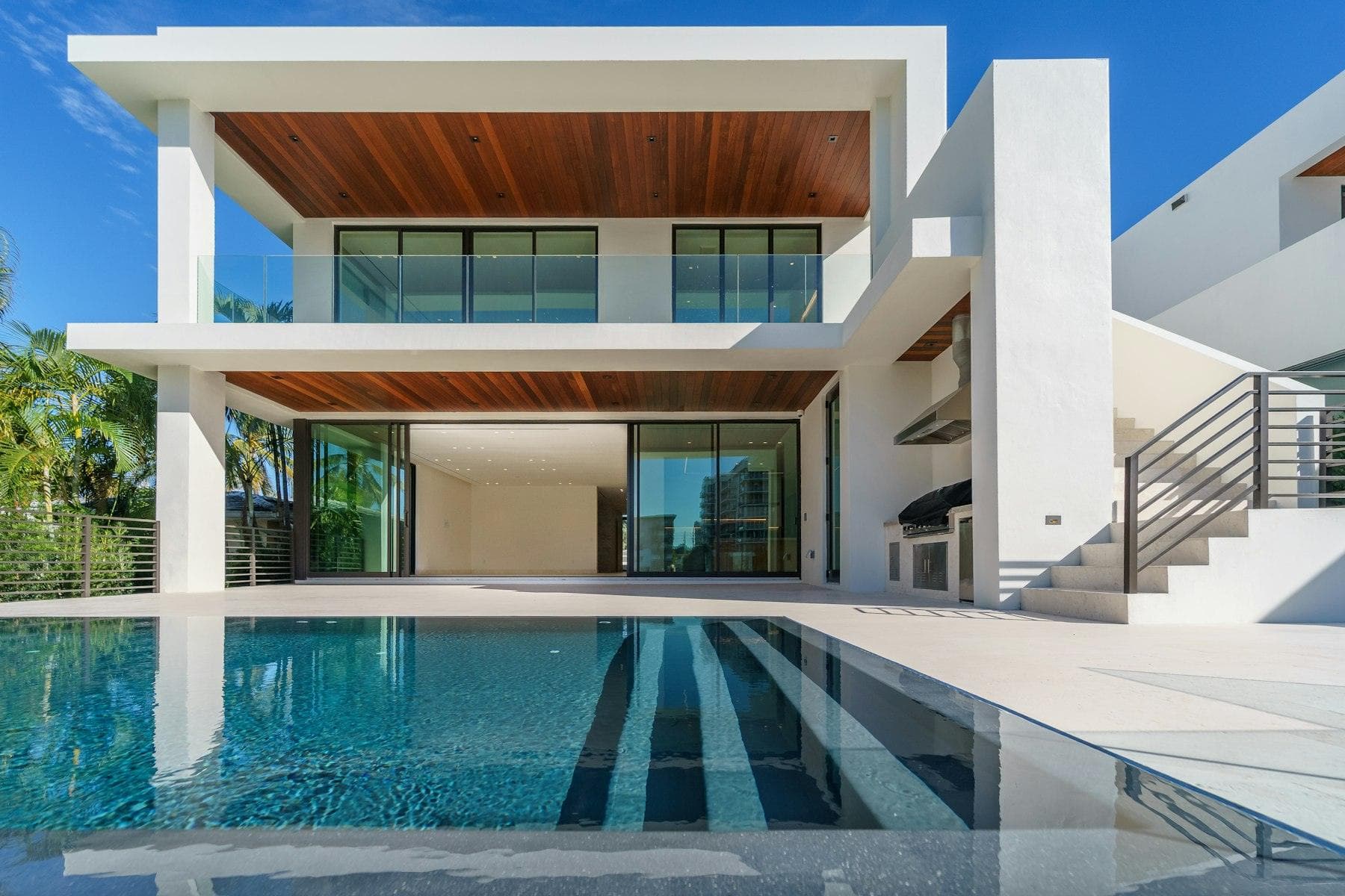 Walk-through of a white villa with a long pool